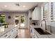 Bright kitchen showcasing white cabinets, a kitchen island, and sliding glass doors leading to the backyard at 241 W Roadrunner Dr, Chandler, AZ 85286