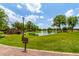 Scenic lake view with lush green grass, walking path, mature trees, and blue skies at 241 W Roadrunner Dr, Chandler, AZ 85286