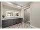 Bathroom featuring dual sinks, granite countertop, dark wood cabinetry, and two lighted mirror panels at 2516 W Joy Ranch Rd, Phoenix, AZ 85086