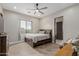 Bedroom with a wood-look tiled floor, ceiling fan, and a bed beneath a window at 2516 W Joy Ranch Rd, Phoenix, AZ 85086