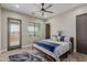 Bright bedroom featuring a modern ceiling fan, neutral walls, wood-look tile flooring, and backyard views at 2516 W Joy Ranch Rd, Phoenix, AZ 85086