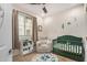 Serene Bedroom with neutral tones, a comfortable chair, and a green-colored crib at 2631 S Sulley Dr # 106, Gilbert, AZ 85295