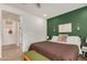 Comfortable bedroom featuring a decorative green accent wall with sconces and a birch tree print at 2631 S Sulley Dr # 106, Gilbert, AZ 85295