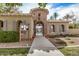 Community clubhouse featuring stone tower, tile roof, arched windows, and wrought iron gate leading to pool area at 2631 S Sulley Dr # 106, Gilbert, AZ 85295