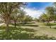 Scenic community park with mature trees, green grass, and playground equipment for outdoor recreation and leisure at 2631 S Sulley Dr # 106, Gilbert, AZ 85295