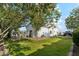 Lush backyard with mature trees providing shade, a well-maintained lawn, and access to the home at 2748 E Warbler Rd, Gilbert, AZ 85297