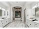 Luxurious bathroom featuring double vanities, marble flooring, large soaking tub and decorative chandelier at 2748 E Warbler Rd, Gilbert, AZ 85297
