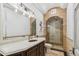 Bathroom featuring a wood vanity, elegant lighting, and a stylish shower with a glass door at 2748 E Warbler Rd, Gilbert, AZ 85297