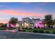 Elegant stucco home featuring manicured landscaping and inviting facade with pink accent lighting at twilight at 2748 E Warbler Rd, Gilbert, AZ 85297