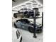 Well-lit garage with a car lift showcasing multiple vehicles and efficient use of space at 2748 E Warbler Rd, Gilbert, AZ 85297