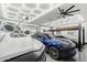 Spacious garage with car lift, modern lighting and ceiling fan showing multiple vehicles and parking at 2748 E Warbler Rd, Gilbert, AZ 85297