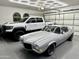Spacious garage featuring epoxy floor, a white Ram TRX truck, and a classic silver Camaro at 2748 E Warbler Rd, Gilbert, AZ 85297