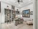 Bright home office with a bookshelf, wooden floors, modern desk, and comfortable seating area at 2748 E Warbler Rd, Gilbert, AZ 85297