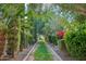 Beautifully landscaped pathway with lush greenery, mature trees, and manicured hedges at 2748 E Warbler Rd, Gilbert, AZ 85297