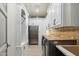Well lit, modern laundry room with white cabinetry, stainless steel refrigerator and front loading washer and dryer at 2748 E Warbler Rd, Gilbert, AZ 85297