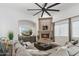 Comfortable living room with corner fireplace, large sectional sofa, and modern ceiling fan at 2748 E Warbler Rd, Gilbert, AZ 85297