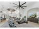 Spacious living area open to the kitchen with modern décor, fireplace, and ceiling fan at 2748 E Warbler Rd, Gilbert, AZ 85297