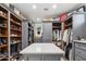 Large closet featuring extensive gray built-ins, open shelving, and a center island with white countertop at 2748 E Warbler Rd, Gilbert, AZ 85297