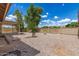 Spacious backyard featuring desert landscaping, mature trees, and a covered patio area at 325 N Redrock St, Gilbert, AZ 85234