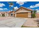 View of a single-story home with a two-car garage and desert landscaping, including a palm tree at 325 N Redrock St, Gilbert, AZ 85234