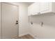 The laundry room features white cabinets for ample storage and is painted with neutral colors at 325 N Redrock St, Gilbert, AZ 85234