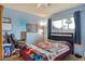 Bright blue bedroom featuring a large window with natural light and a ceiling fan at 3410 W Pershing Ave, Phoenix, AZ 85029