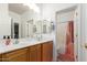 Well-lit bathroom featuring dual sinks, a wood vanity, and a separate toilet and shower area for added privacy at 3523 W Buckhorn Trl, Phoenix, AZ 85083