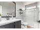 Modern bathroom with sleek black fixtures, a glass-enclosed shower, and stylish shelving for decor and essentials at 3523 W Buckhorn Trl, Phoenix, AZ 85083