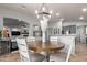 Cozy dining area featuring a round wooden table, seating for four, stylish chandelier, and seamless flow to the living area at 3523 W Buckhorn Trl, Phoenix, AZ 85083