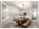 Dining room with a large wooden table, seating for eight, and bright natural light filtering through shuttered windows at 3523 W Buckhorn Trl, Phoenix, AZ 85083
