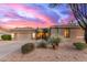 Charming single-story home showcasing a manicured desert landscape and three-car garage, bathed in the warm hues of sunset at 3523 W Buckhorn Trl, Phoenix, AZ 85083