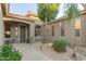 Inviting front entry with decorative plants, lanterns, and a desert landscape, complete with accent lighting and a palm tree at 3523 W Buckhorn Trl, Phoenix, AZ 85083