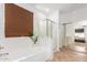 Bright main bathroom with a large soaking tub, a walk-in shower, and a view into the bedroom through mirrored doors at 3523 W Buckhorn Trl, Phoenix, AZ 85083