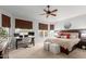 Spacious main bedroom featuring a ceiling fan, large windows for natural light, and a cozy sitting area with ottomans at 3523 W Buckhorn Trl, Phoenix, AZ 85083