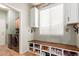 Bright mud room with custom shoe bench, storage cabinets, and washer and dryer at 3523 W Buckhorn Trl, Phoenix, AZ 85083