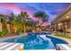 Stunning pool area with lush greenery, lounge chairs, and outdoor seating at dusk at 3523 W Buckhorn Trl, Phoenix, AZ 85083