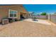Desert landscaped backyard featuring a concrete patio with furniture and an air conditioning unit at 36412 W Pampoloma Ave, Maricopa, AZ 85138