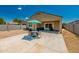 Backyard featuring a concrete patio with an umbrella and table surrounded by desert landscaping at 36412 W Pampoloma Ave, Maricopa, AZ 85138
