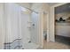 Bright bathroom featuring a white tiled shower stall and a view into the walk-in closet at 36412 W Pampoloma Ave, Maricopa, AZ 85138