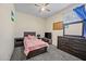 Bright bedroom with a full bed, neutral walls, carpet flooring, and a large window at 36412 W Pampoloma Ave, Maricopa, AZ 85138