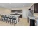 Modern kitchen with an island, seating, stainless steel appliances and dark wood cabinets at 36412 W Pampoloma Ave, Maricopa, AZ 85138