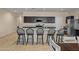 Modern kitchen showcasing an island with barstool seating, dark cabinets and stainless steel appliances at 36412 W Pampoloma Ave, Maricopa, AZ 85138