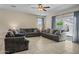 Bright living room featuring tile floors, comfortable sofas, and large windows with natural light at 36412 W Pampoloma Ave, Maricopa, AZ 85138