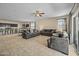 Spacious open-concept living room and kitchen featuring tiled floors, neutral walls, and modern furnishings at 36412 W Pampoloma Ave, Maricopa, AZ 85138