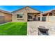 Well-maintained backyard with a small lawn, covered patio, and paver area at 39985 W Rio Lobo Dr, Maricopa, AZ 85138