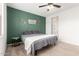 Bedroom featuring a queen-sized bed, a side table, and a green accent wall at 39985 W Rio Lobo Dr, Maricopa, AZ 85138