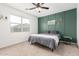 Cozy bedroom with a queen bed and a decorative green accent wall at 39985 W Rio Lobo Dr, Maricopa, AZ 85138