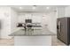 Modern kitchen with stainless steel appliances, granite countertops, and white cabinetry at 39985 W Rio Lobo Dr, Maricopa, AZ 85138