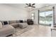 Bright living room with modern sectional couch, tile flooring, and backyard access at 39985 W Rio Lobo Dr, Maricopa, AZ 85138
