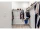 Walk-in closet with shelving and hanging storage space for clothing and shoes at 39985 W Rio Lobo Dr, Maricopa, AZ 85138